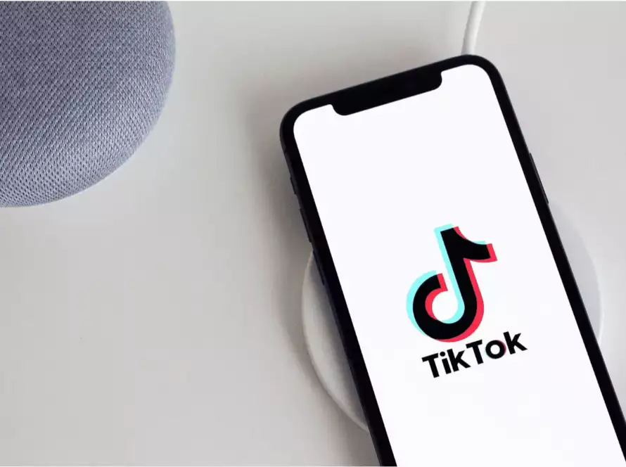 tiktok sur un ecran iphone, sur une table blanche