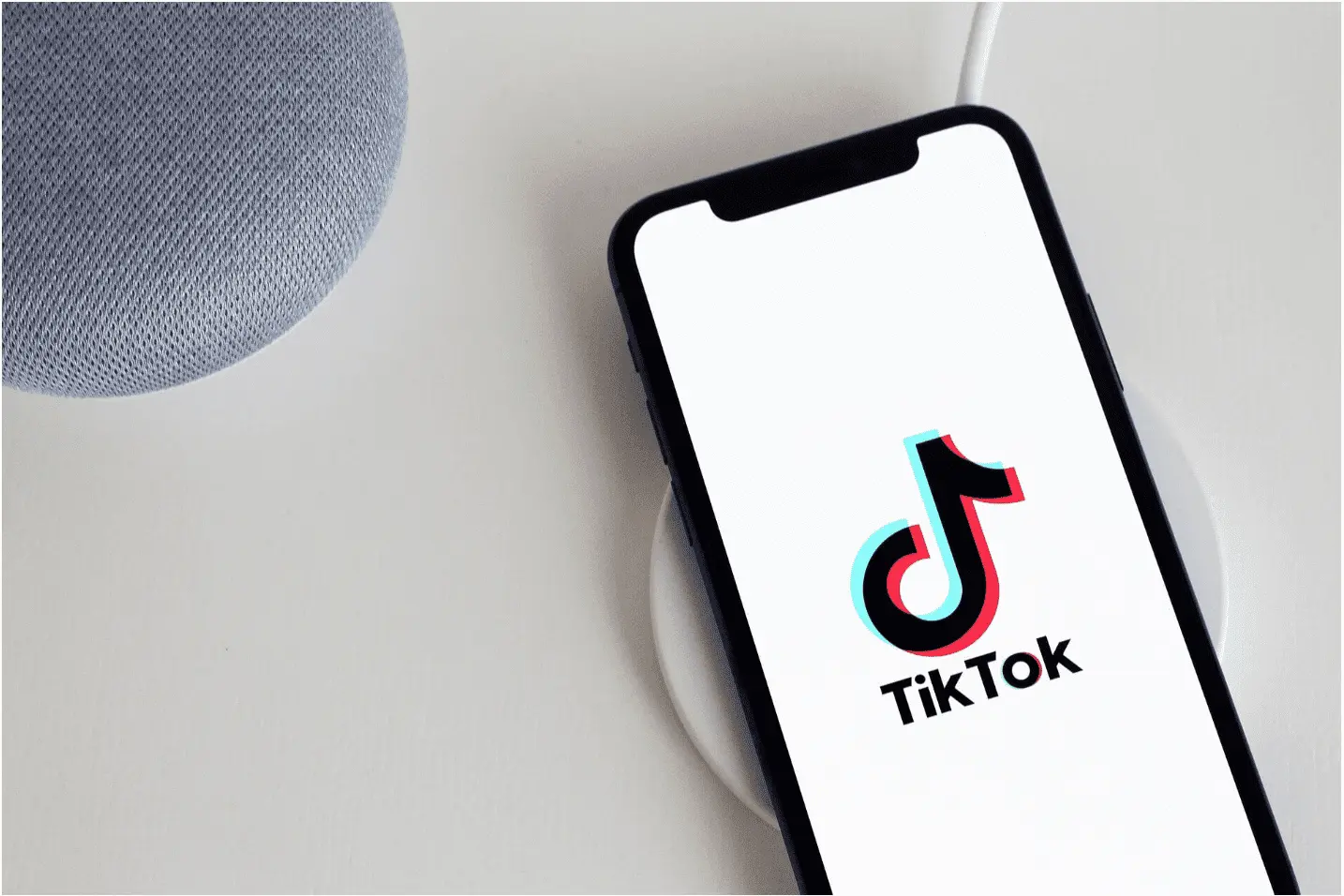 tiktok sur un ecran iphone, sur une table blanche